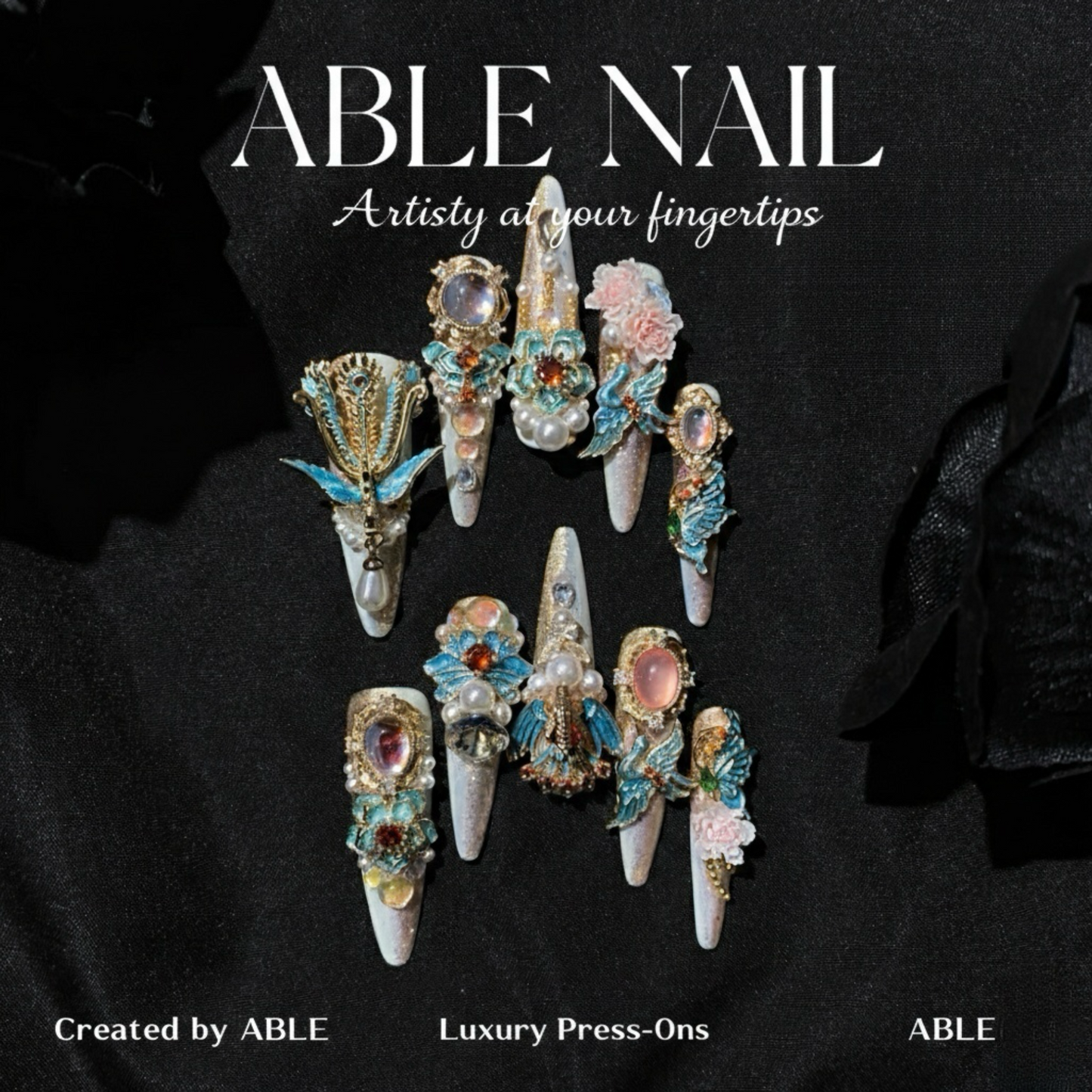 Decorative nail art with gemstones and flowers on a black background, featuring the brand 'ABLE'.