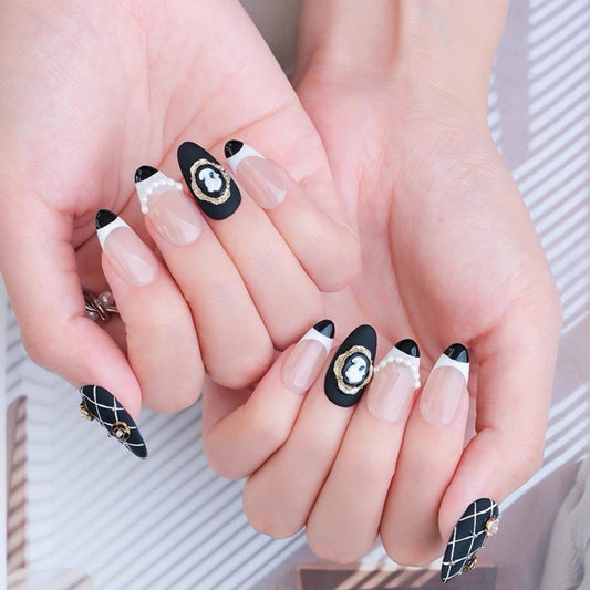 Close-up of hands with black and white nail art on a neutral background