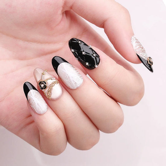 Hand with black and white nail design on a light pink background