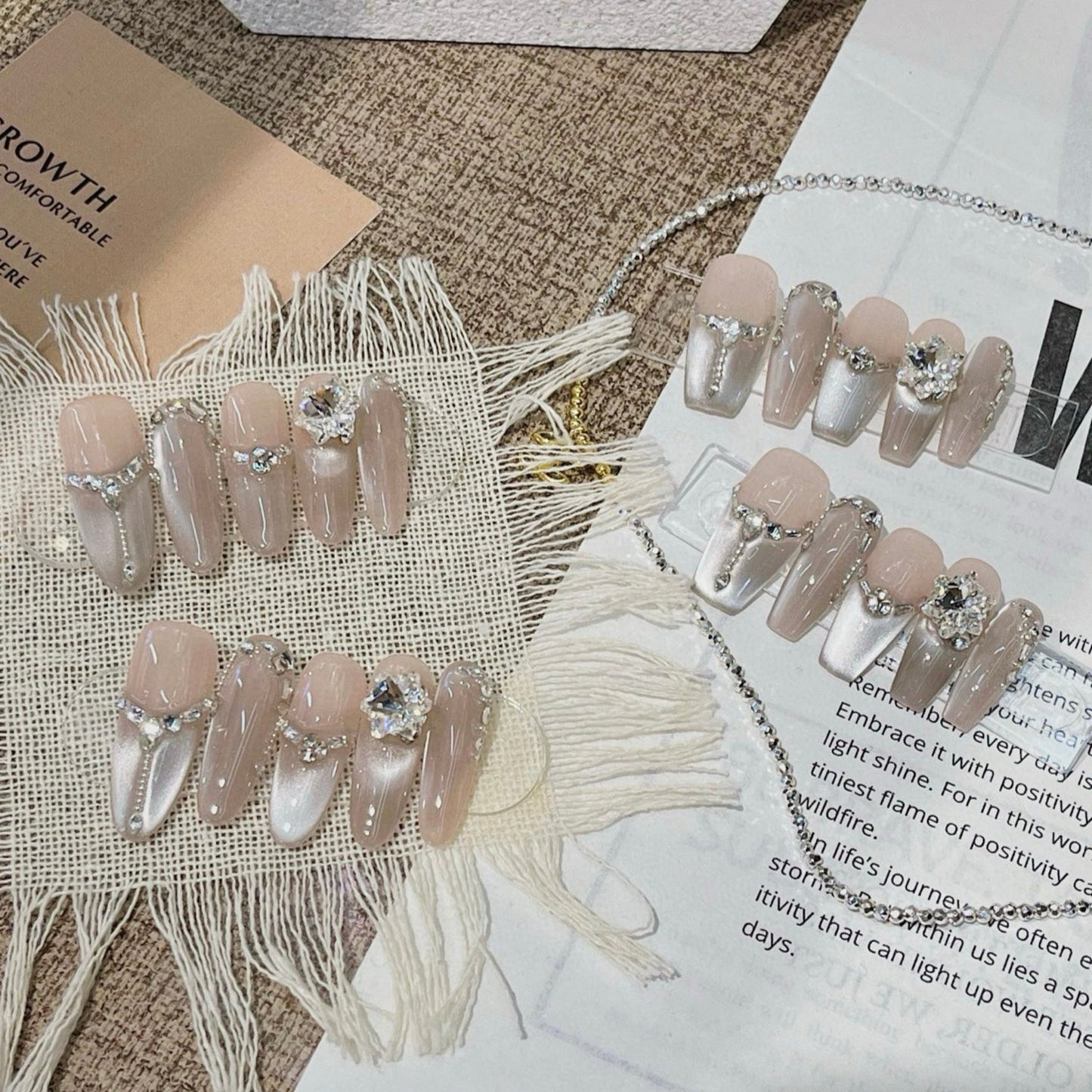 Set of decorative nails with rhinestones on a textured surface with fringe