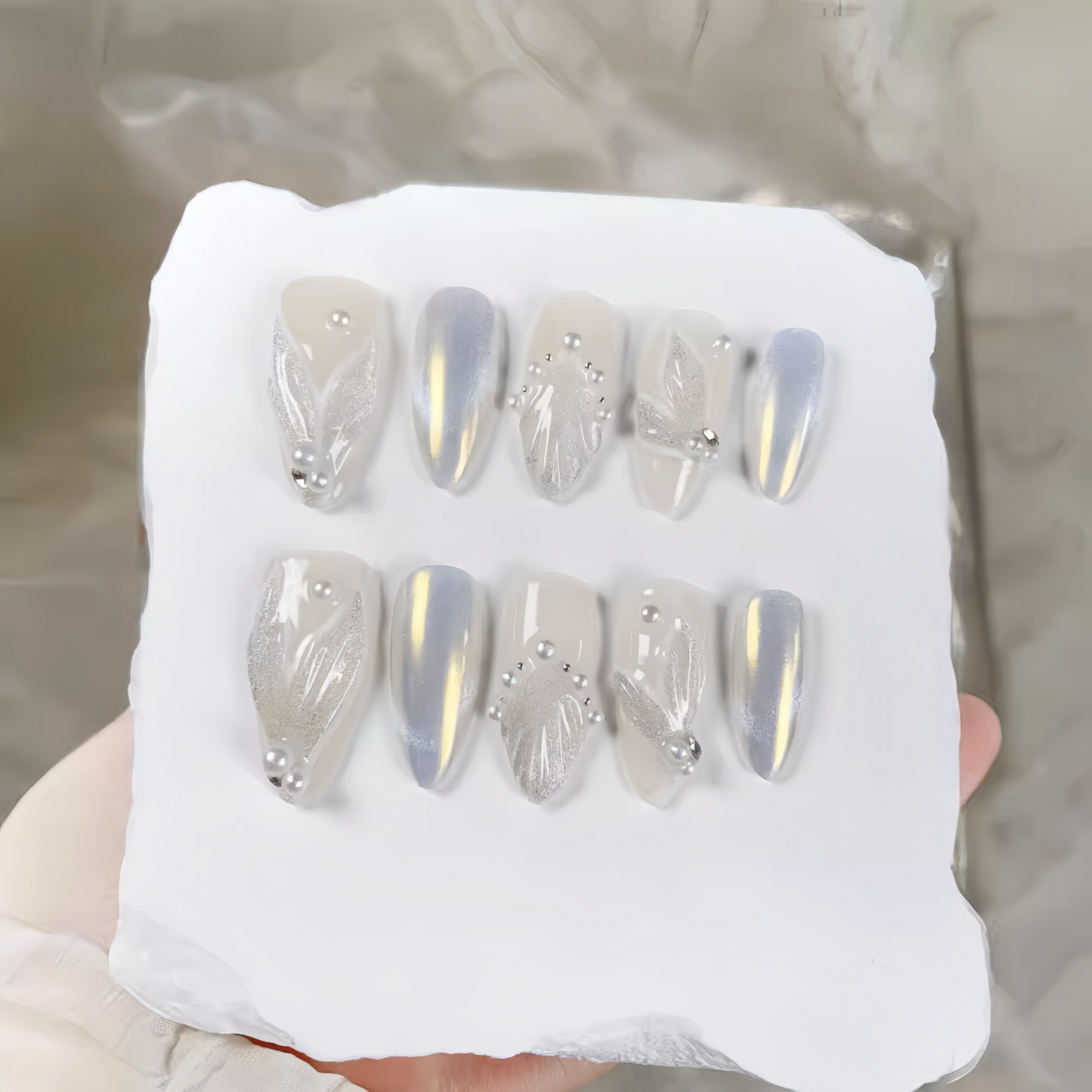 Set of decorative nails on a white block with a neutral background