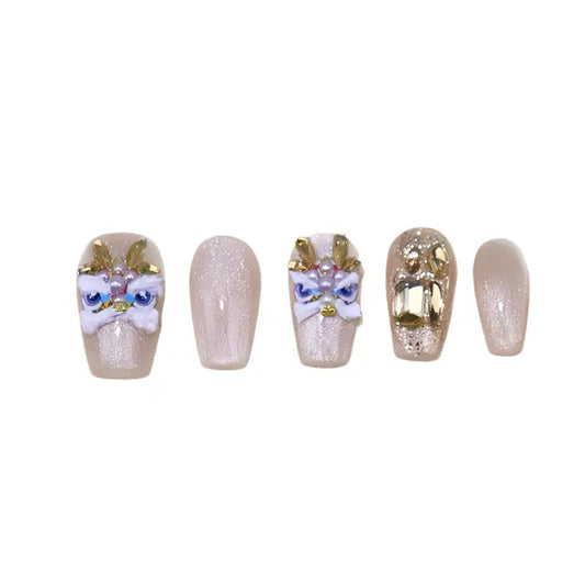 Set of five decorative nails with gold, white, and blue designs on a white background