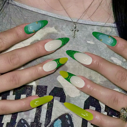 Close-up of hands with green and white nail polish on a patterned surface