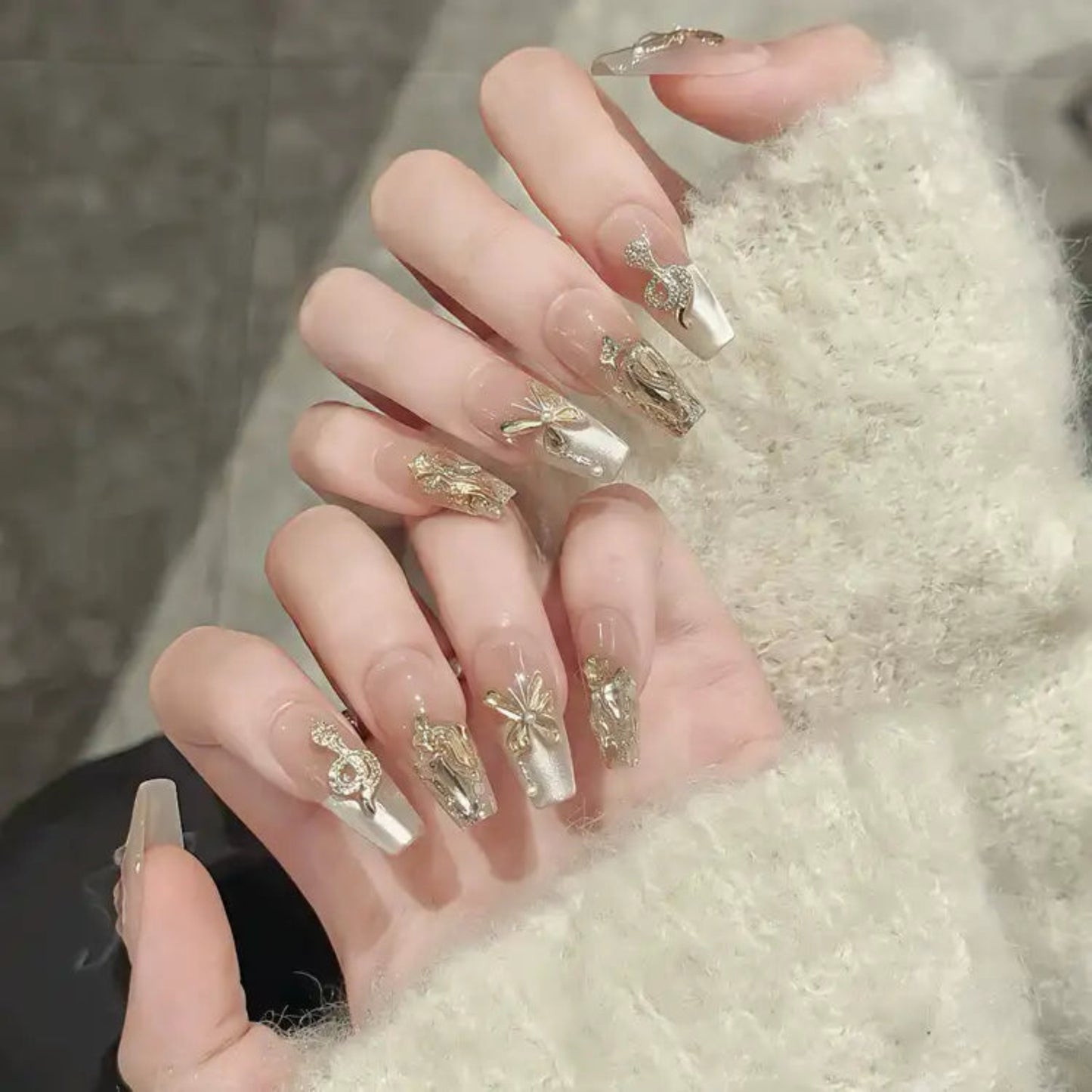 Close-up of a hand with decorative nail art on a textured surface