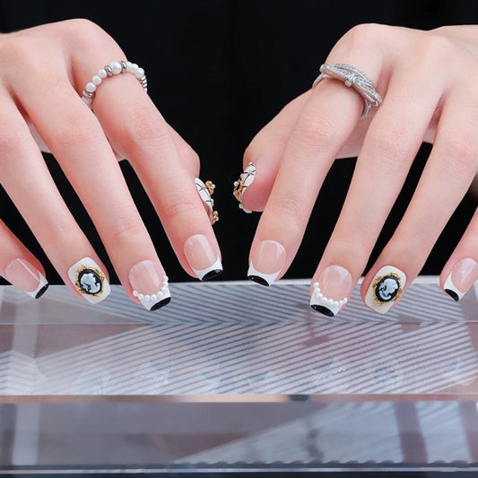 Close-up of hands with decorative nail art on a reflective surface