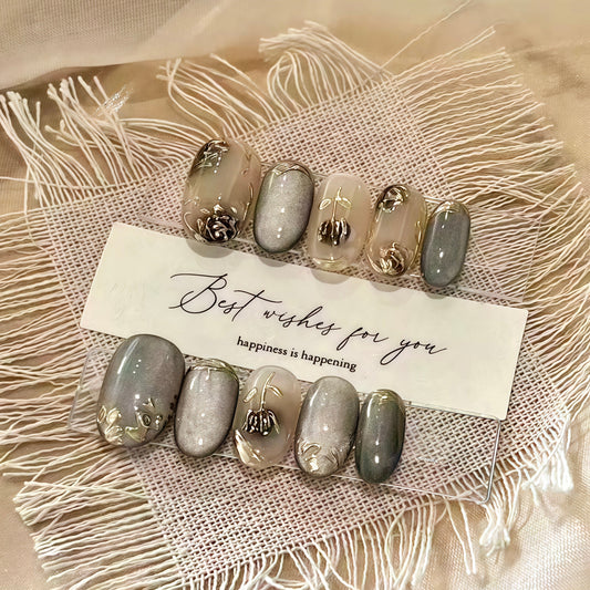 Set of decorative nails with gold accents on a textured surface with a card reading 'Best wishes for you, happiness is happening'.