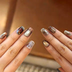 Close-up of hands with glittery nail polish on a blurred background