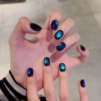 Hand with dark blue and purple gradient nail polish on a neutral background