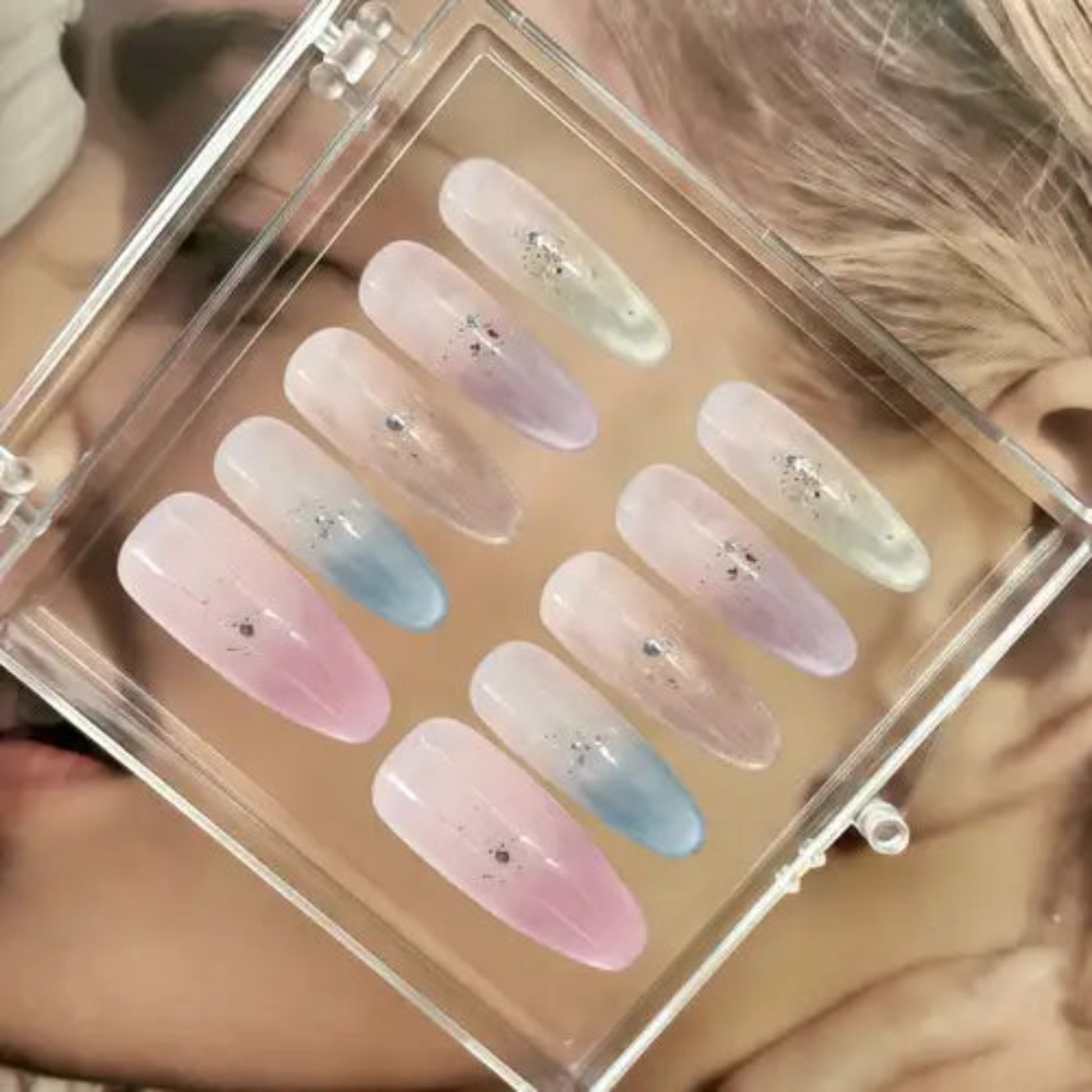 Set of pastel-colored nail samples in a clear display case.