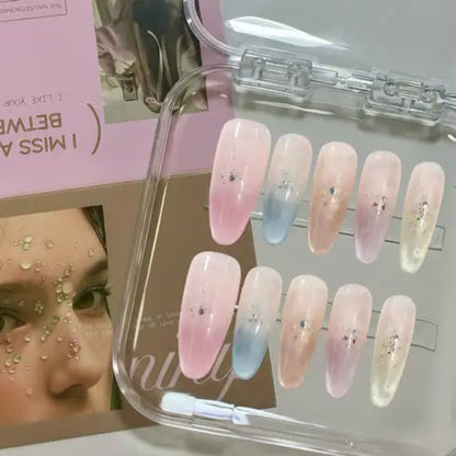 Set of false nails with a gradient design in pink, blue, and white, displayed in a clear case.