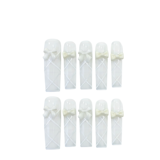 Set of white baby booties with bow details on a white background