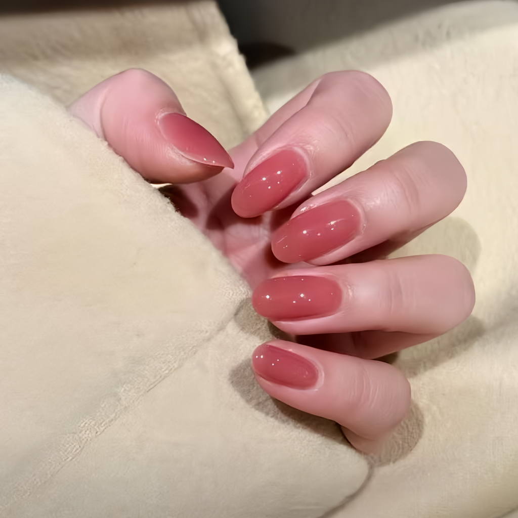 Close-up of a hand with pink nail polish on a beige background