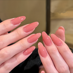 Close-up of hands with pink nail polish against a neutral background