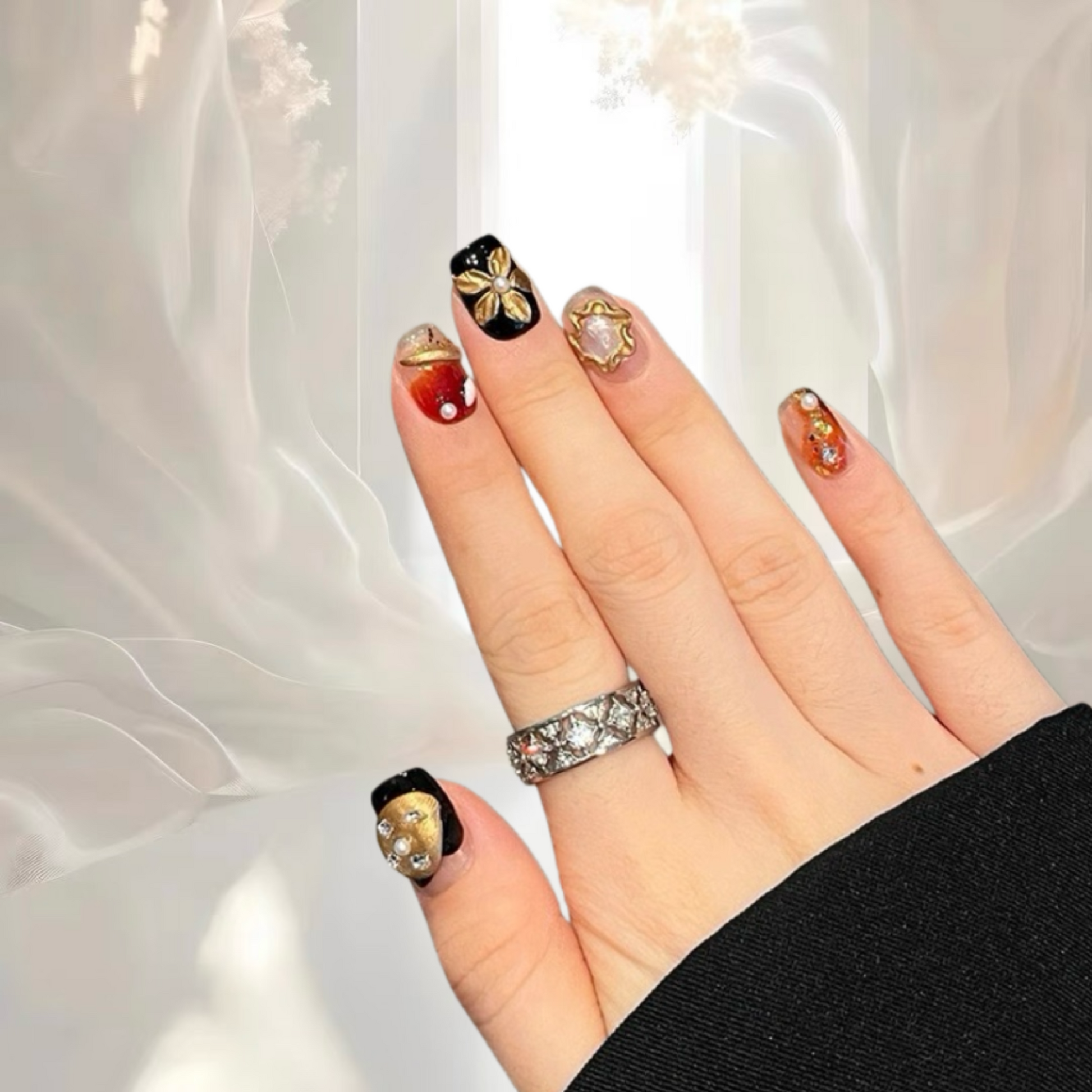 Hand with decorated nails and a ring against a light background