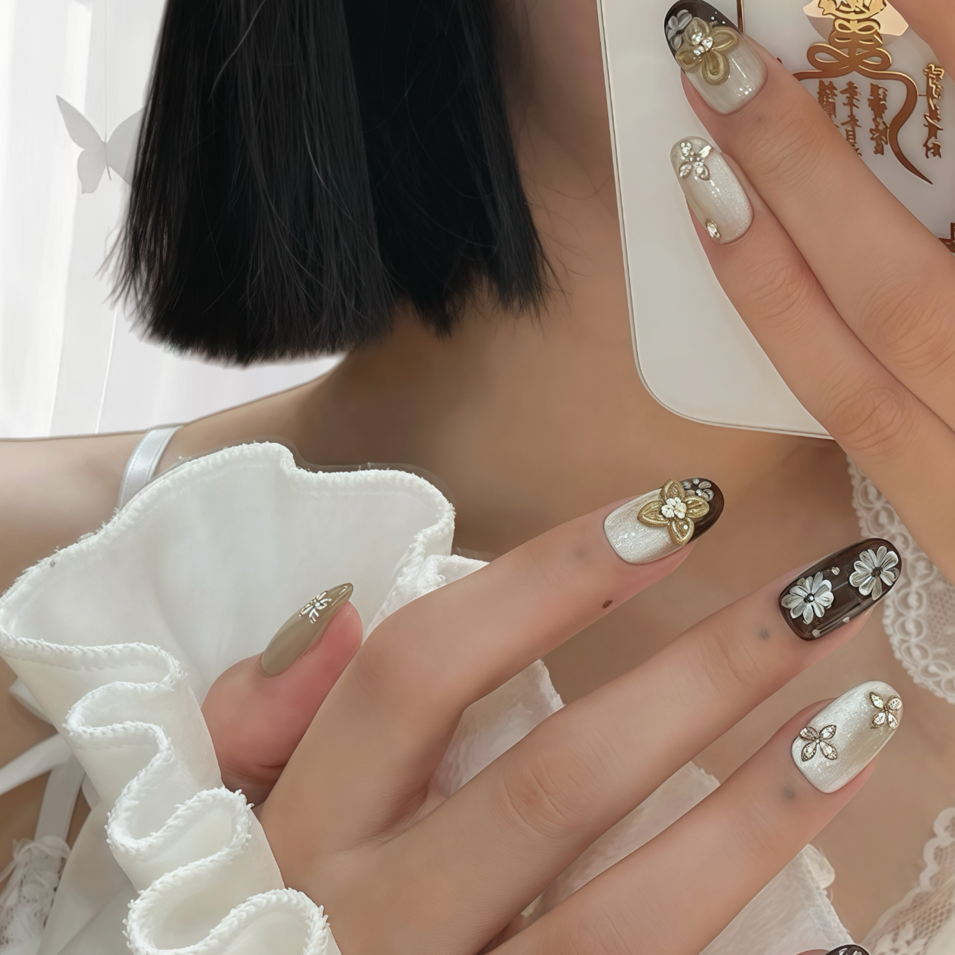 Close-up of a hand with decorative nail art holding a phone.