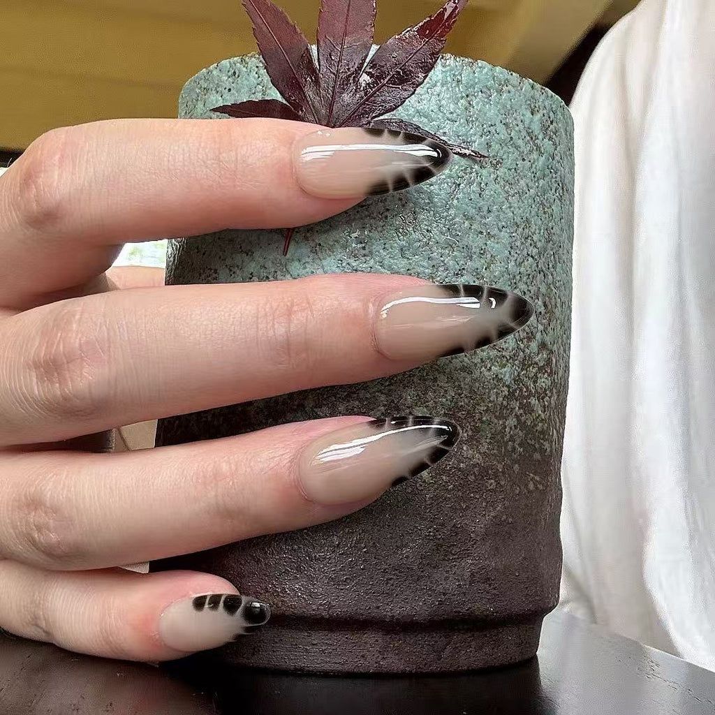 Hand with decorative nails holding a small plant pot