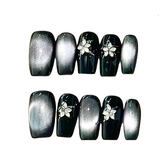 Black and gray gradient nails with floral designs on a white background