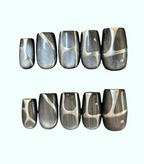 Set of silver and black marbled nail art designs on a white background