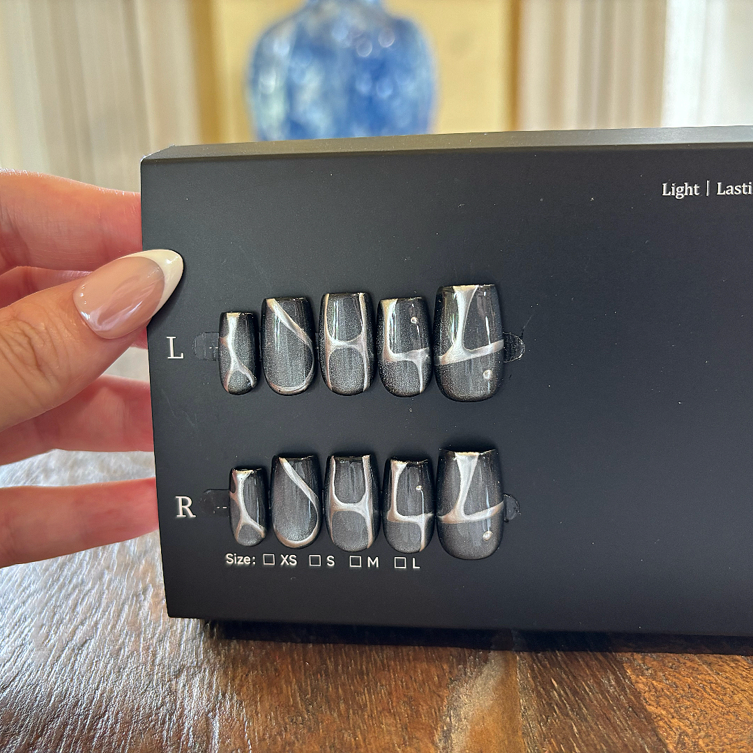 Black box with textured 'L' and 'R' labels held by a hand on a wooden surface.