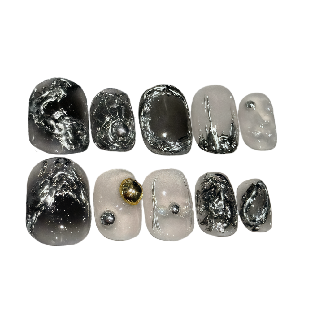 Set of nail art designs with black, white, and gold on a white background