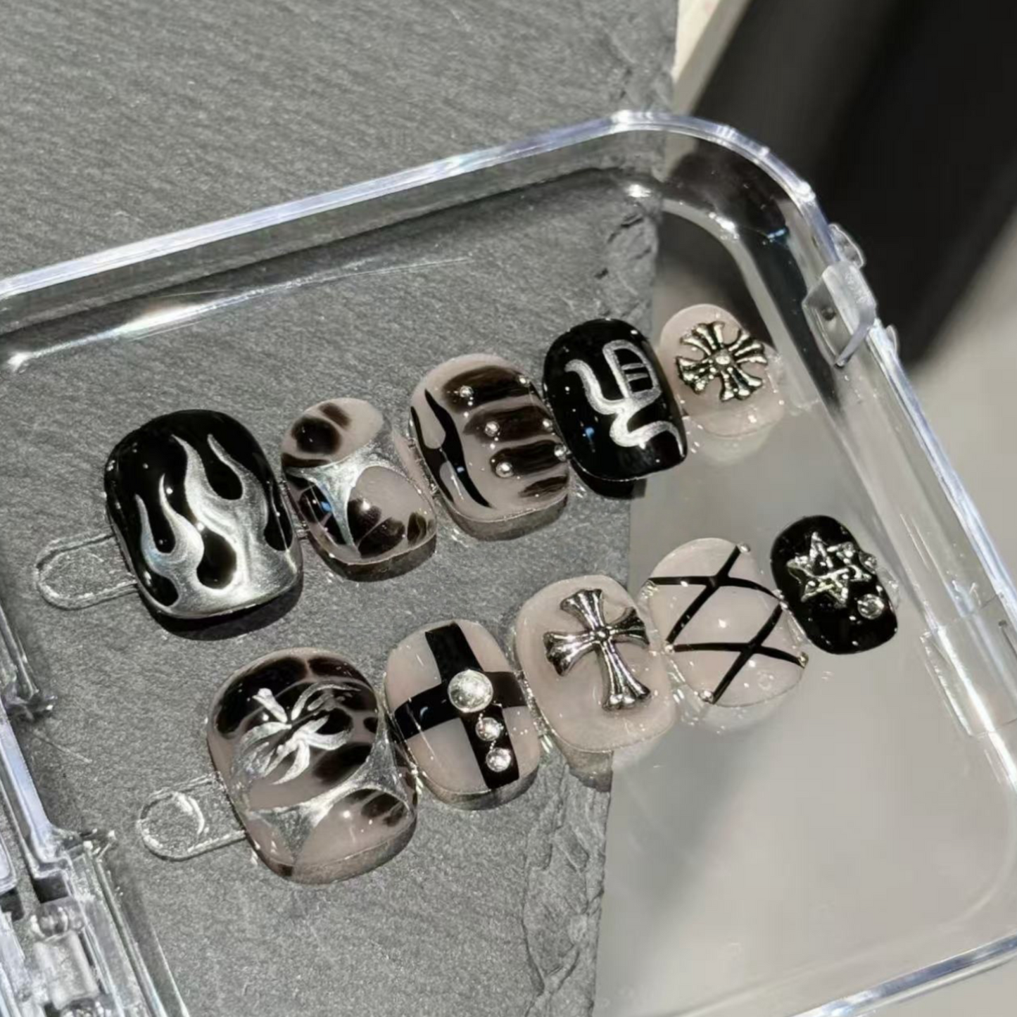Set of black and silver nail art designs in a clear case.