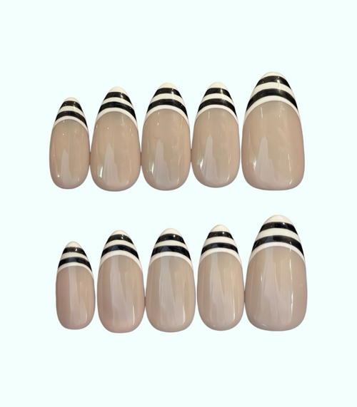 Set of beige nail extensions with black and white stripes on a white background