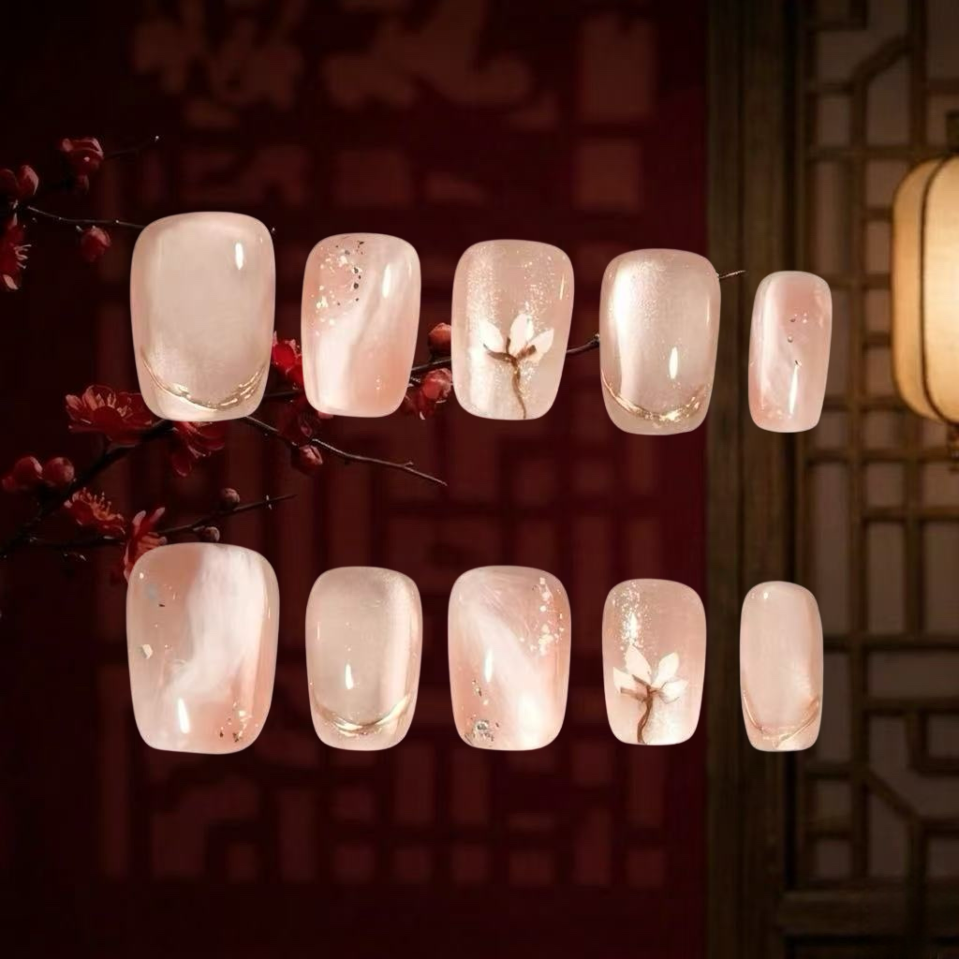 Set of light pink nail polish samples with floral design on a dark background