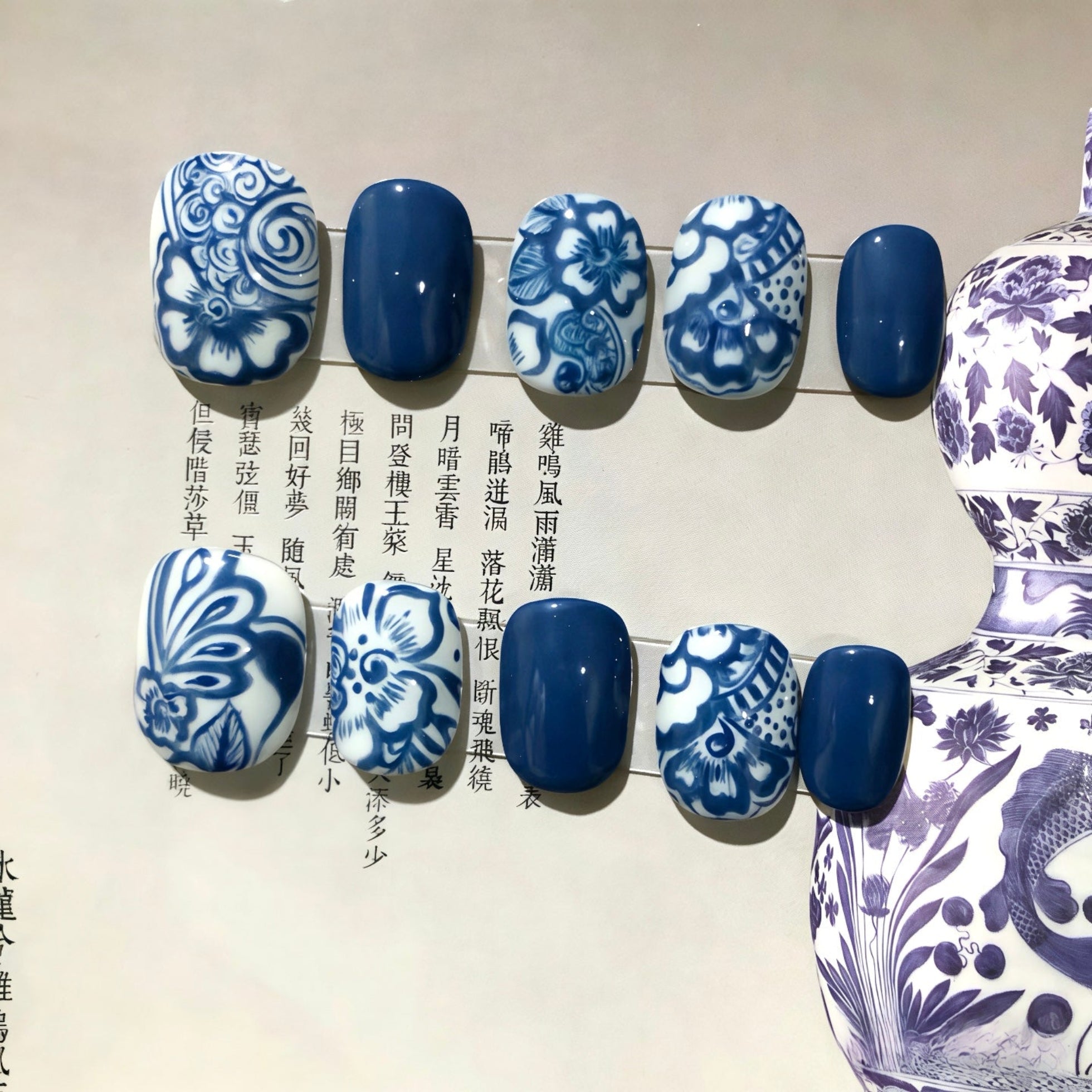 Nails with blue and white floral patterns on a beige background