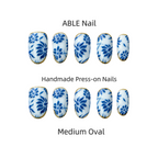 Handmade press-on nails with blue floral design on a white background, labeled 'ABLE Nail'.