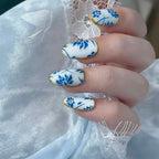 Nails with blue floral design on a white lace background