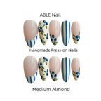 Set of ABLE Nail press-on nails in medium almond color with decorative patterns on a white background.