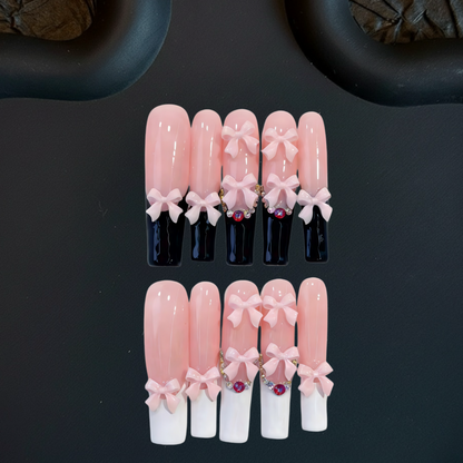 Set of pink and white artificial nails with decorative bows on a black background