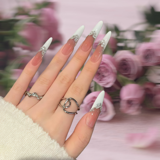Hand with decorative nails and rings against a floral background