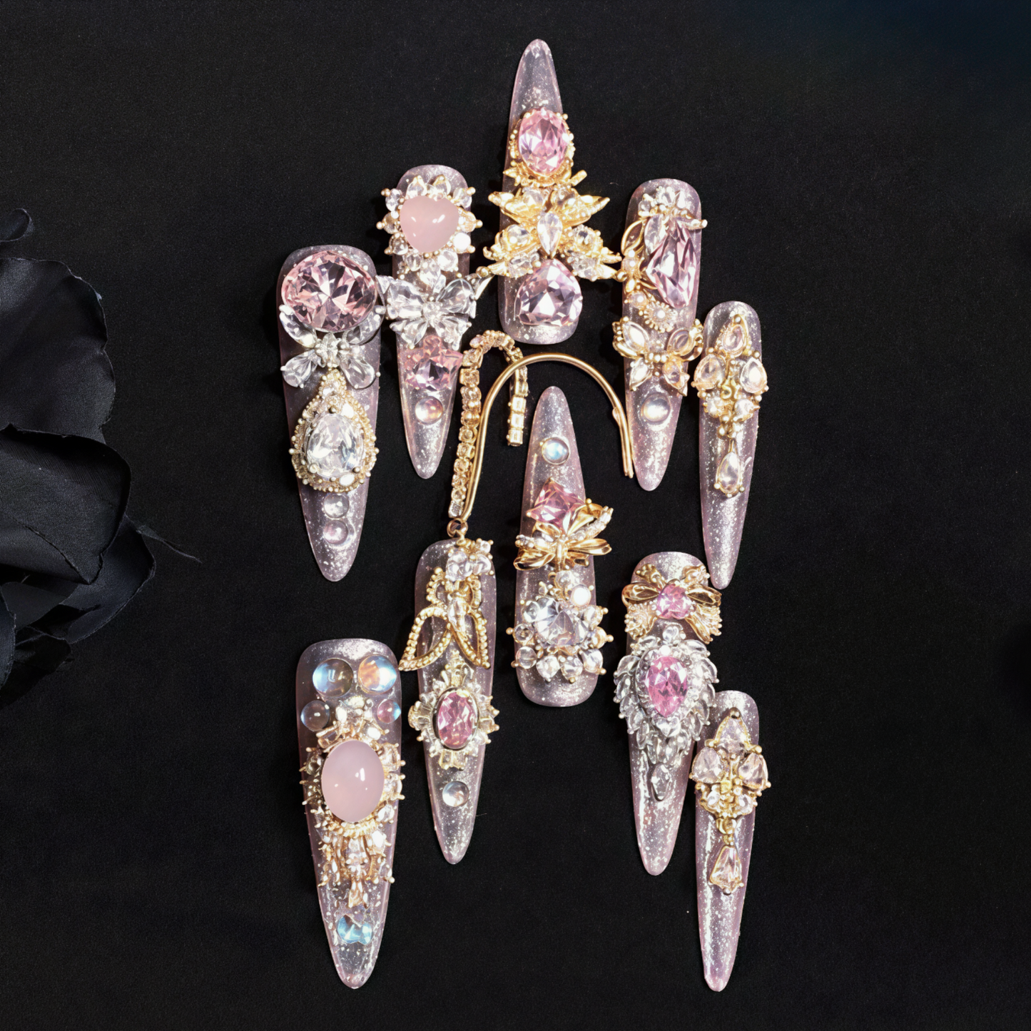 Decorative nail art with gemstones and gold accents on a black background