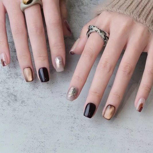 Close-up of hands with various nail polish colors on a neutral background