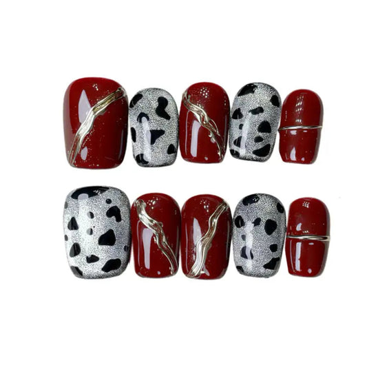 Set of nail designs with red, silver, and black patterns on a white background