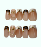 Set of nails with gold and white designs on a white background