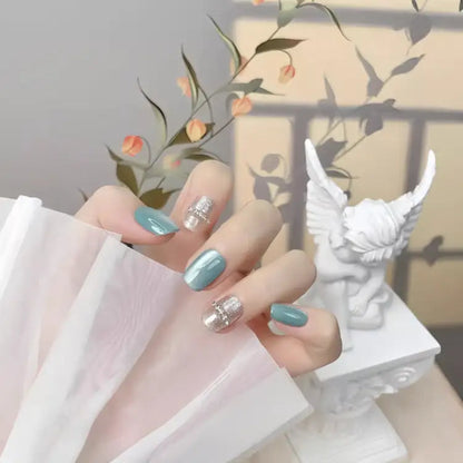 Hand with light blue and silver nail polish holding a white fabric, with a decorative background.