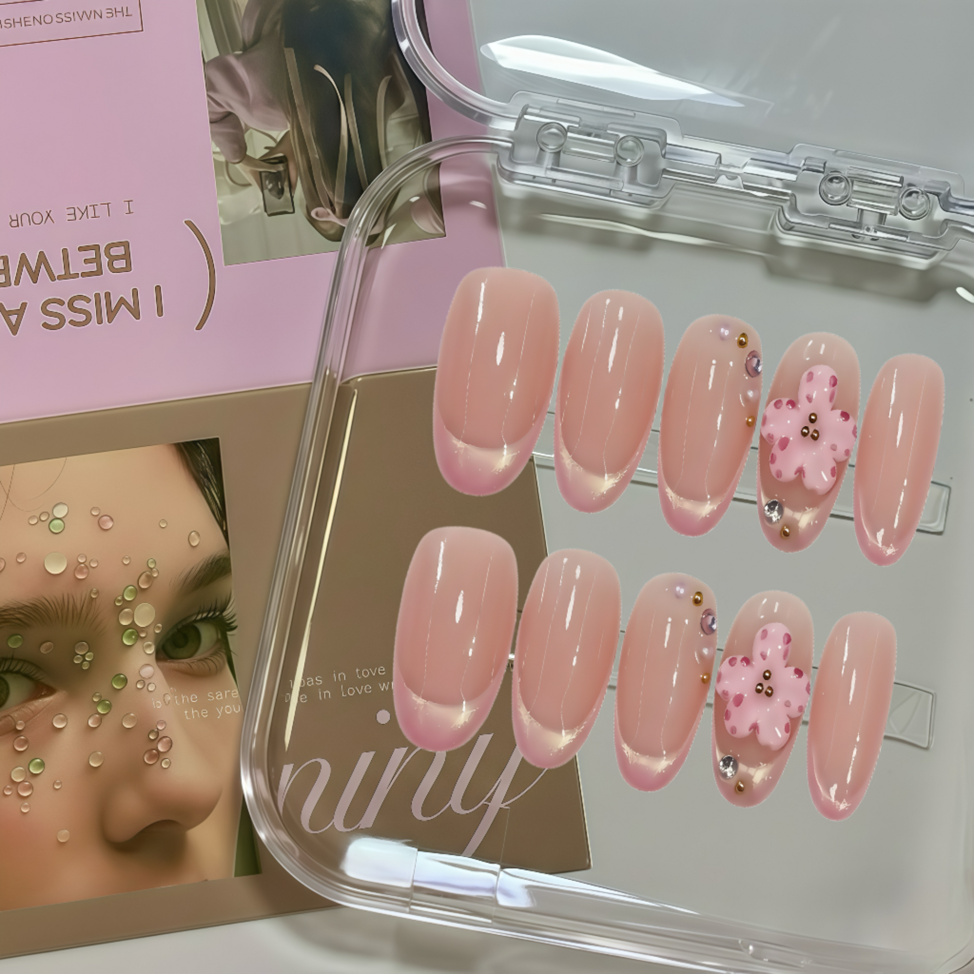 Set of pink nail designs in a clear case with a magazine in the background