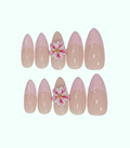 Set of pink and beige nail art with floral decorations on a white background