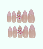 Set of pink and beige nail art with floral decorations on a white background