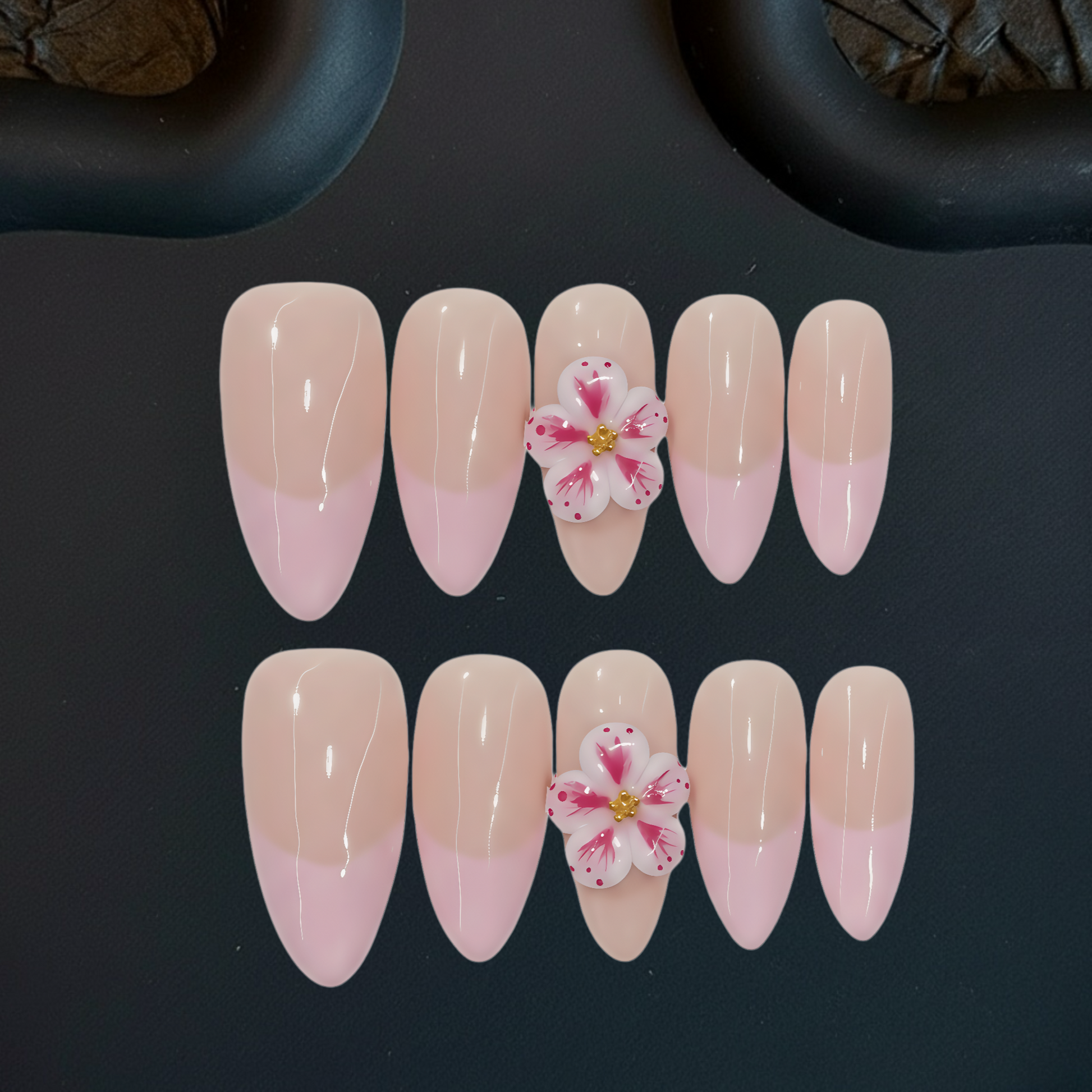 Set of pink and beige gradient nails with floral decorations on a dark background