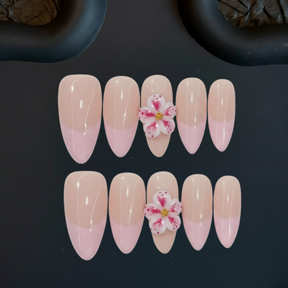 Set of pink and beige gradient nails with floral decorations on a dark background