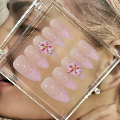 Set of pink nail art with floral designs in a clear case.