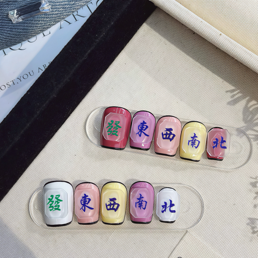 Set of colorful nail art with Chinese characters on a clear stand.