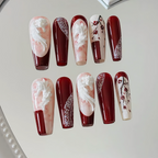 Nail art set with red and white designs on a light background