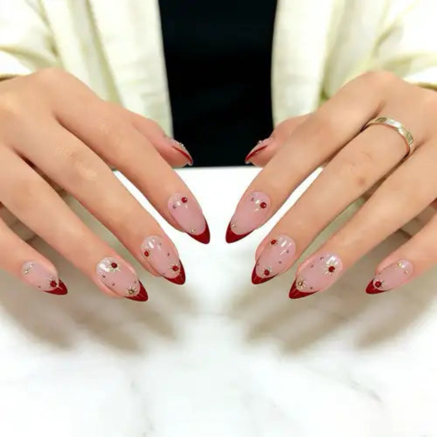 Close-up of hands with pink and red nail polish on a white background