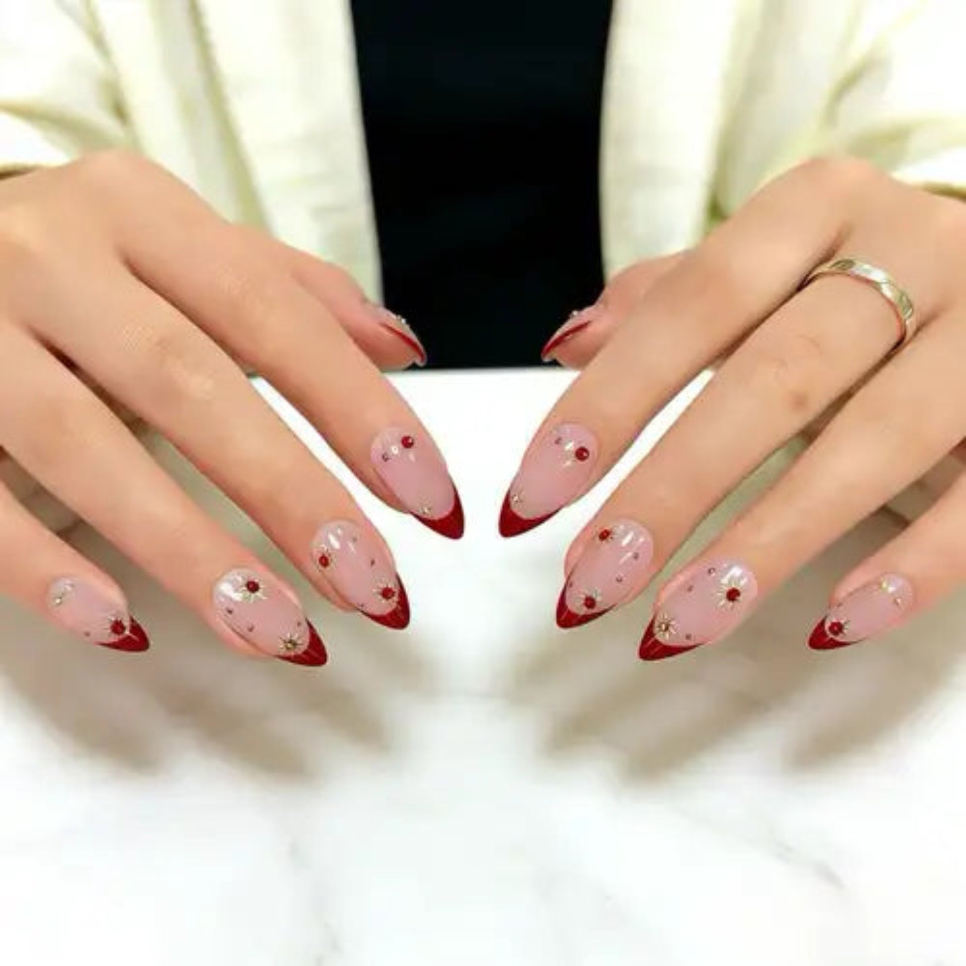 Close-up of hands with pink and red nail polish on a white background