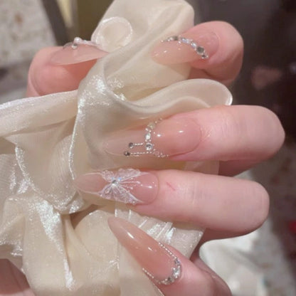 Close-up of hands with decorative nail art holding a white bow.