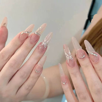 Close-up of hands with decorative nail art on a neutral background